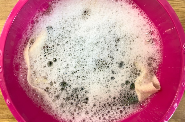 Agitating the water to get soap suds