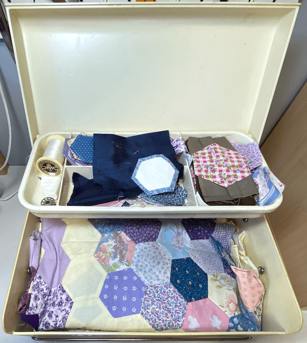 Repurposed baby box used for quilt storage – a sustainable sewing room organization hack.