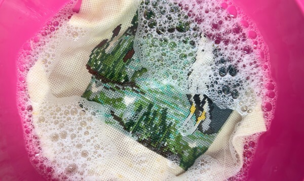 dirty cross stitch soaking in warm soapy water