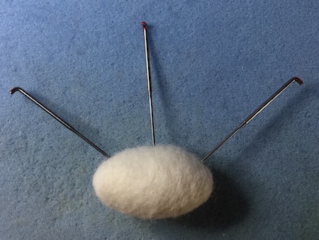 Photo showing the direction in which to stab the felted ball Photo showing the direction in which to stab the felted ball