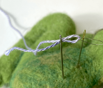 pulling thread through eye of needle