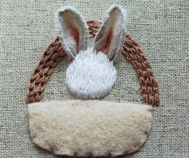 Bunny head embroidered with long and short stitch over felt padding