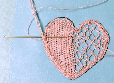 Buttonholing the edge of the needle lace heart over the cordonet