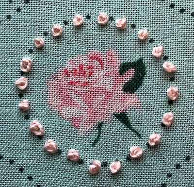 Colonial knots stitched in a ring around a rose design