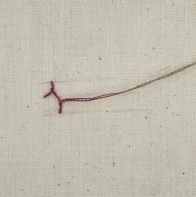 Cretan stitch step 3 — first complete stitch