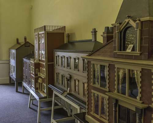 Antique dolls' houses lining the wall of the Dolls' House Room at Wallington