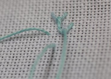 Step 3 in working single feather stitch