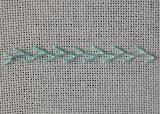 Row of single feather stitch worked on evenweave