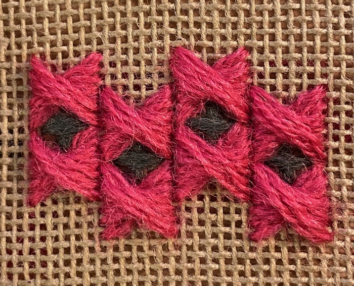 Half Rhodes stitch with gaps filled with upright cross stitch in red and green