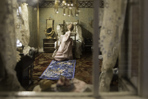 Bedroom inside Hammond House dolls' house with a miniature needlepoint rug