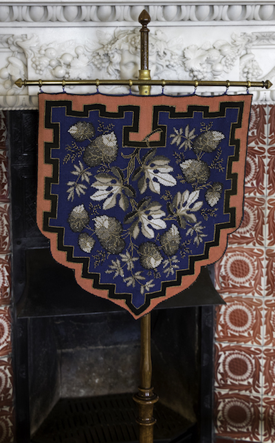Shield shaped heraldic banner fire screen in tent stitch and metal threads in the Library at Wallington
