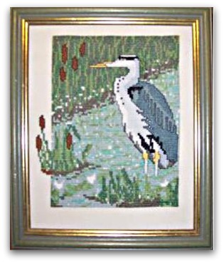 Heron counted cross stitch design standing in water among reeds