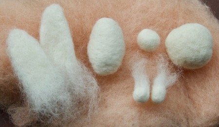 Felted shapes for the bunny — ears, head, tail, cheeks, and body