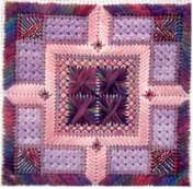 Tranquility needlepoint design stitched in pink shiny thread with gobelin stitches that catch the light against a darker matte border