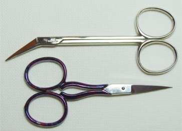 Two pairs of embroidery scissors with fine, pointed blades — one angled, one straight — for precise Hardanger thread cutting