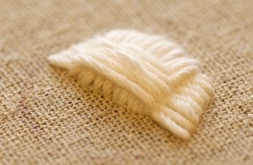 Padding with soft cotton thread to create a raised shape