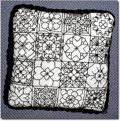 Blackwork Pincushion sampler with multiple small motifs in a checkerboard layout