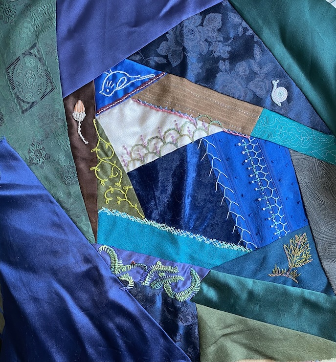 The start of the crazy quilt block showing blues, greens and mixed fabrics