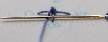 Step 5: a different camera angle showing how the needle slides under the spoke