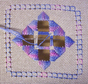 Beginning the framework for the spider's web filling stitch, showing the thrown thread and first wraps