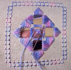 Working the spiral spider's web at the centre of the Hardanger coaster, showing the weaving in progress