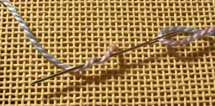 Step 1 of a needlepoint french knot