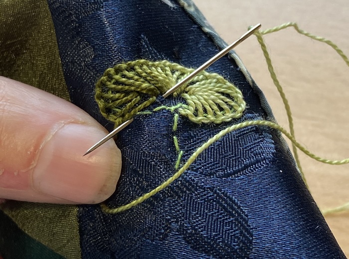 Working the blanket stitch lily pad in the hand without a hoop