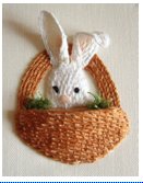 Stumpwork bunny sitting inside a couched basket