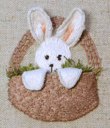 Bunny with basket attached, paws draped over the rim, and facial features added