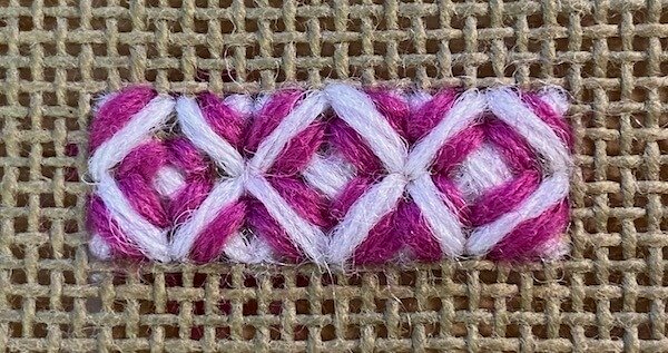 Completed triple rice stitch in white with cerise tie-down stitches