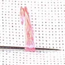 Pulling the thread through the fabric while using a laying tool to keep them under control